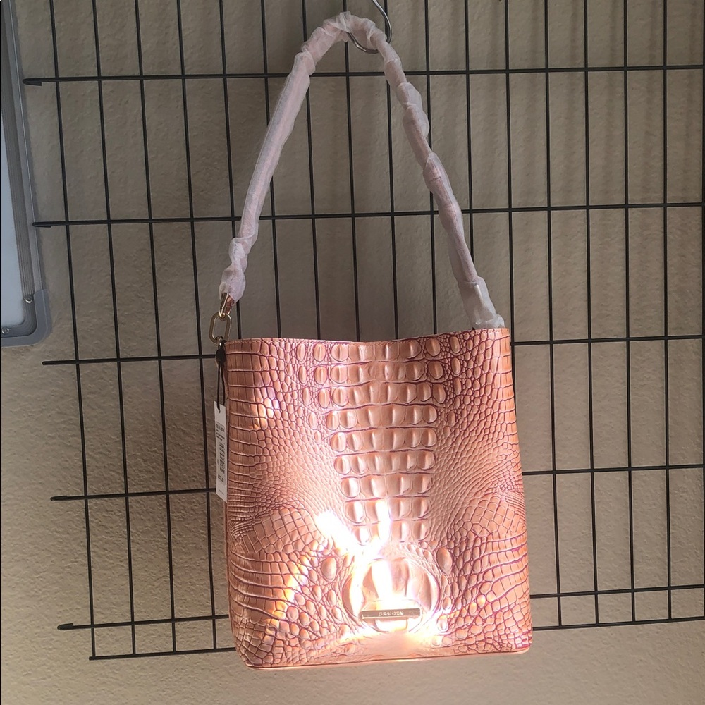 This is beautiful peach colored bucket styled handbag with raspberry veining.